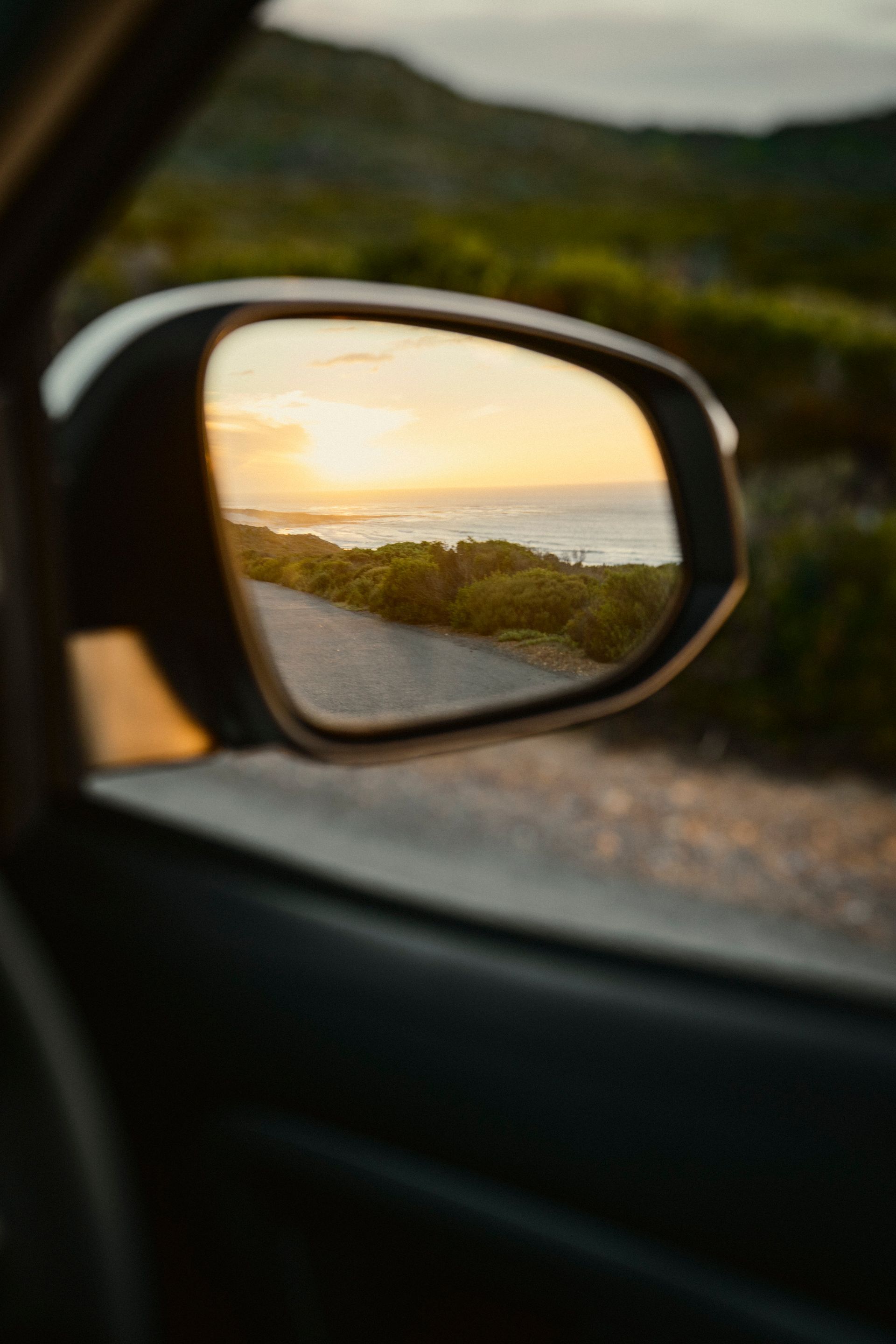 Blick auf das Meer durch den Seitenspiegel eines Autos