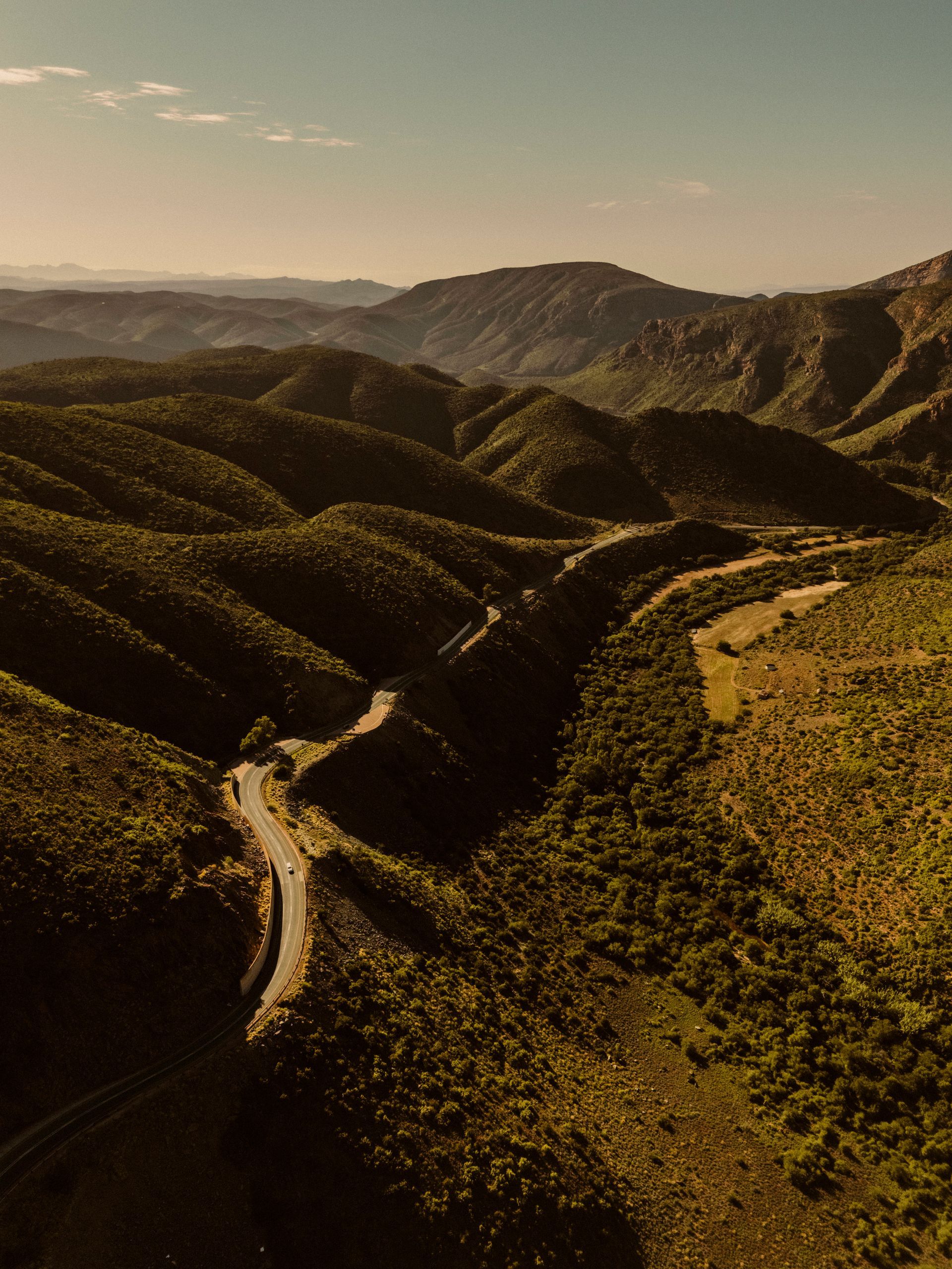 Blick über grüne Berge und sich windender Straße.