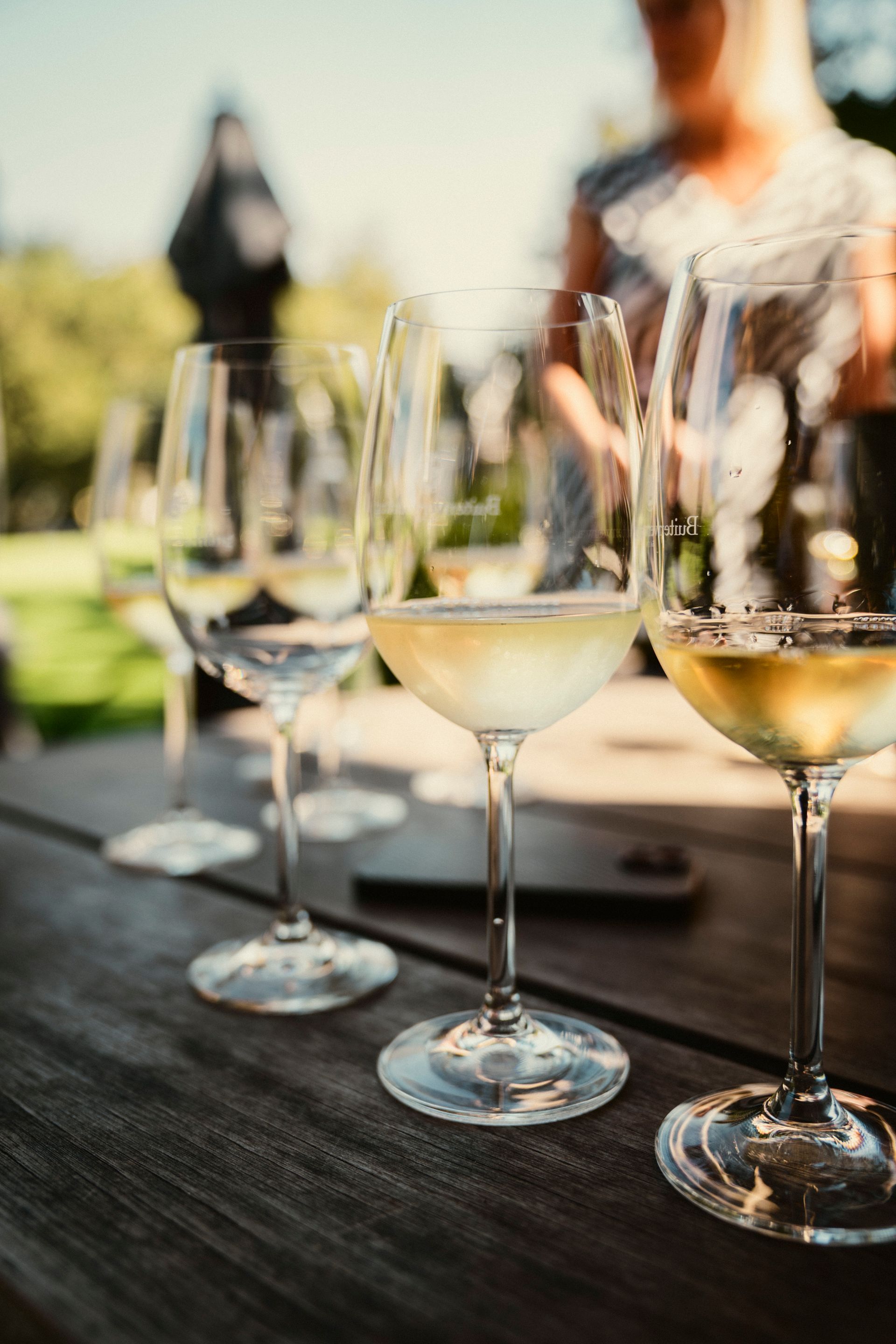 Tisch mit verschiedenen Weingläsern teilweise gefüllt bei einer Weinprobe