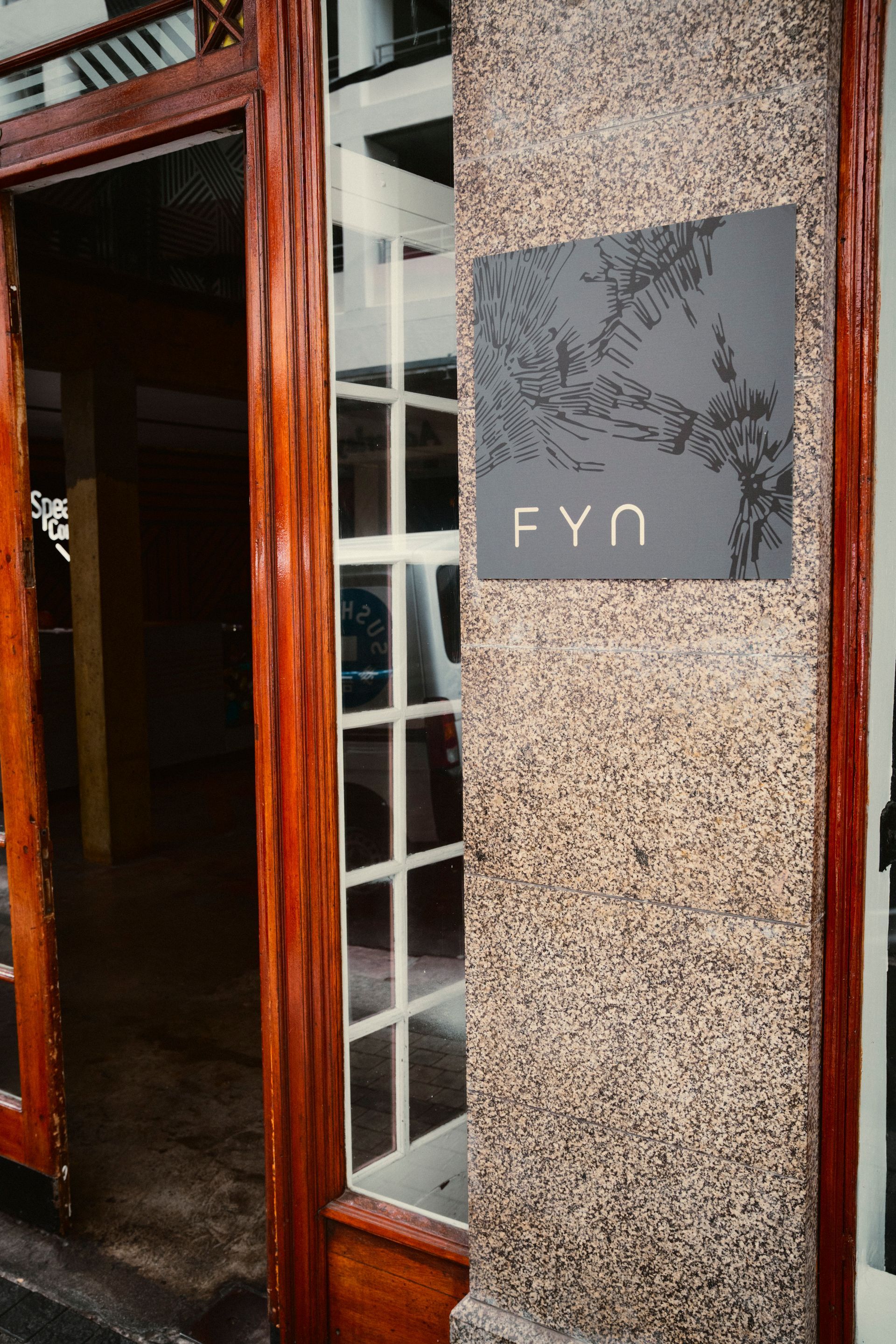 Eingang vom FYN Restaurant mit schwarzem Schild mit weißer Schrift