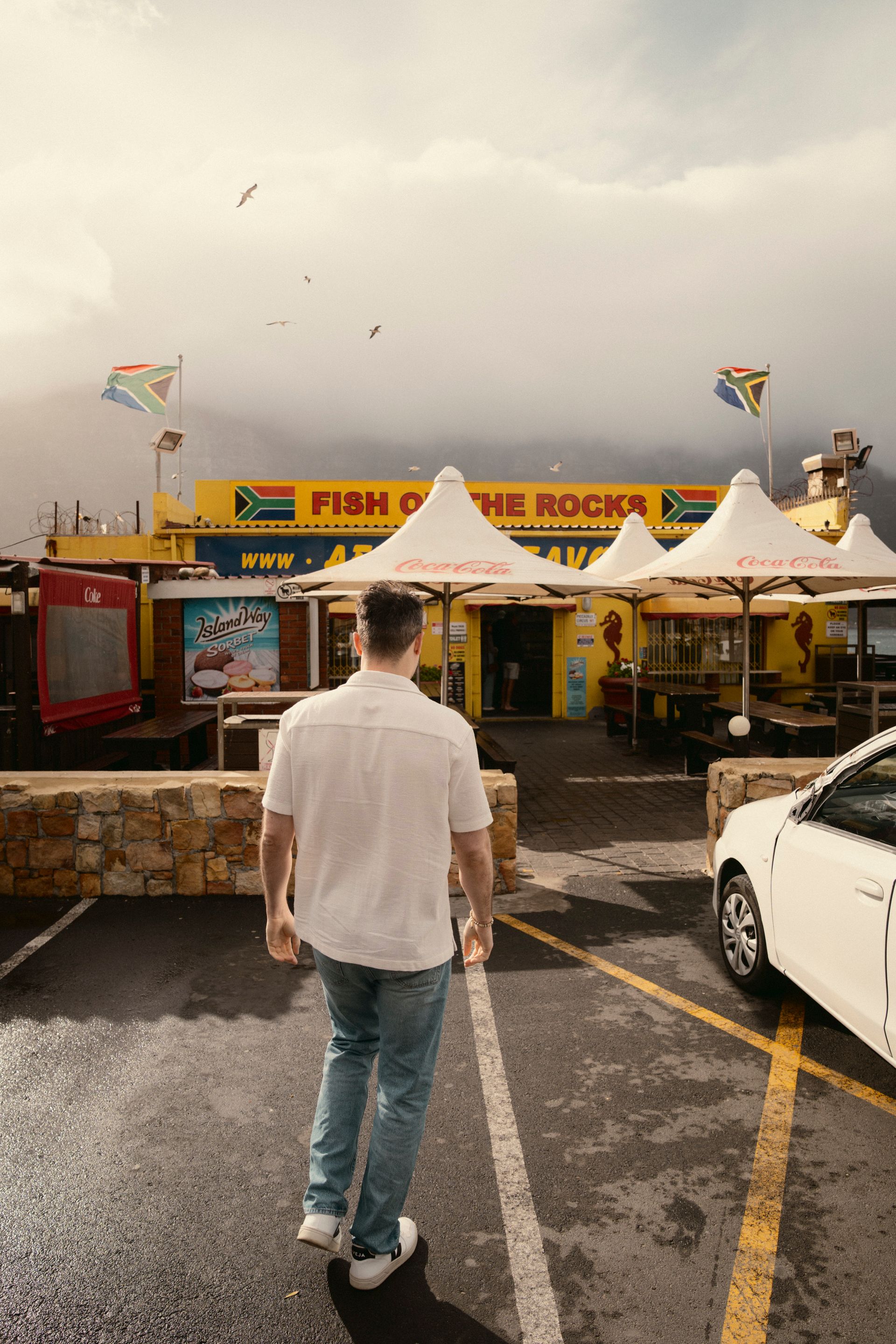 Markus auf Parkplatz vor gelbem Imbiss Fish on the Rocks