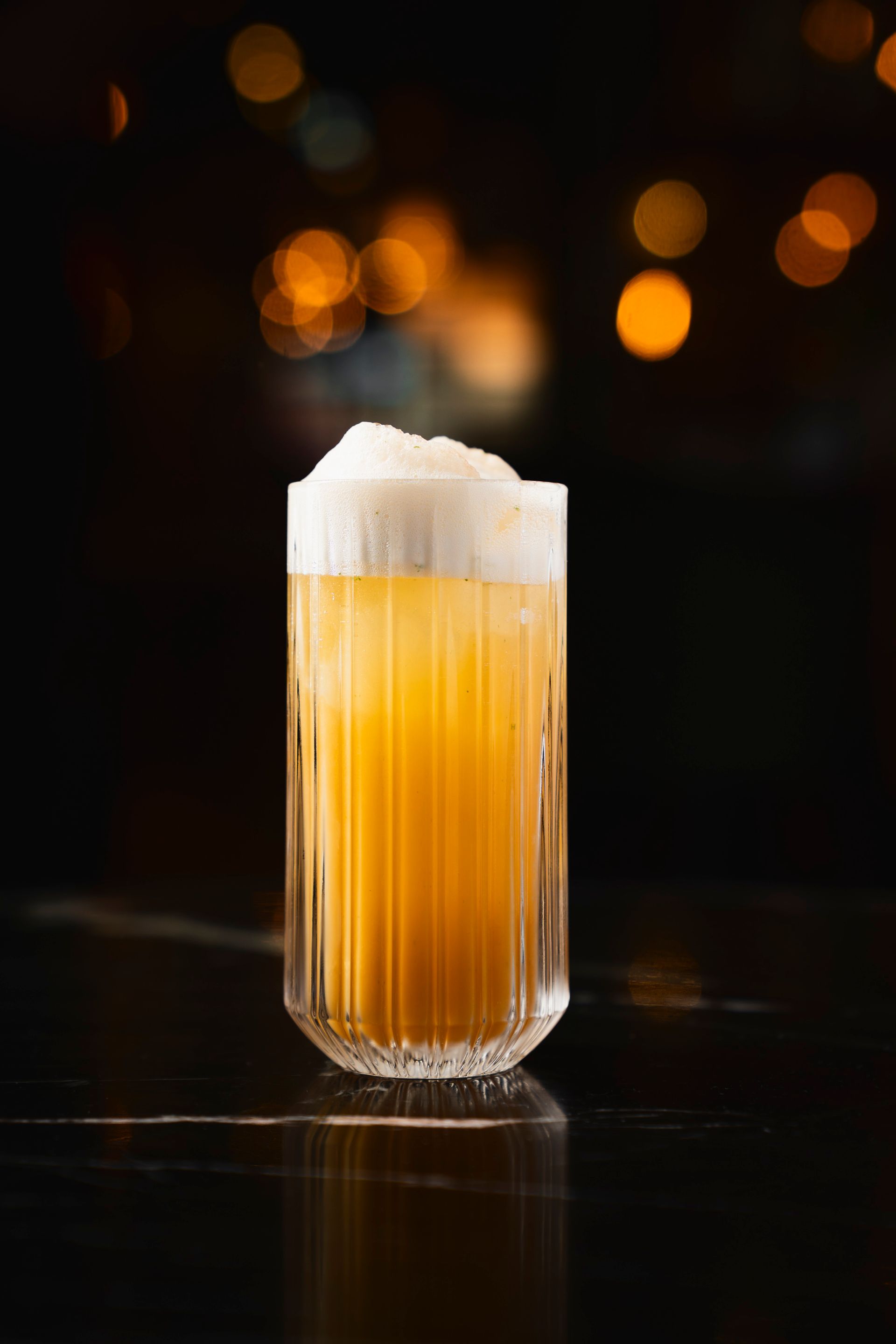 Highballglas mit TABLE MOUNTAIN Cocktail. Gelb mit cremiger Schaumkrone