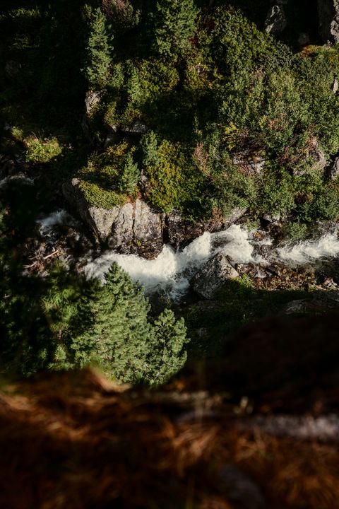 Marie Conde sitzt an einem gedeckten Tisch mit Weingläsern in einem hellblauen Hemd und lächelt