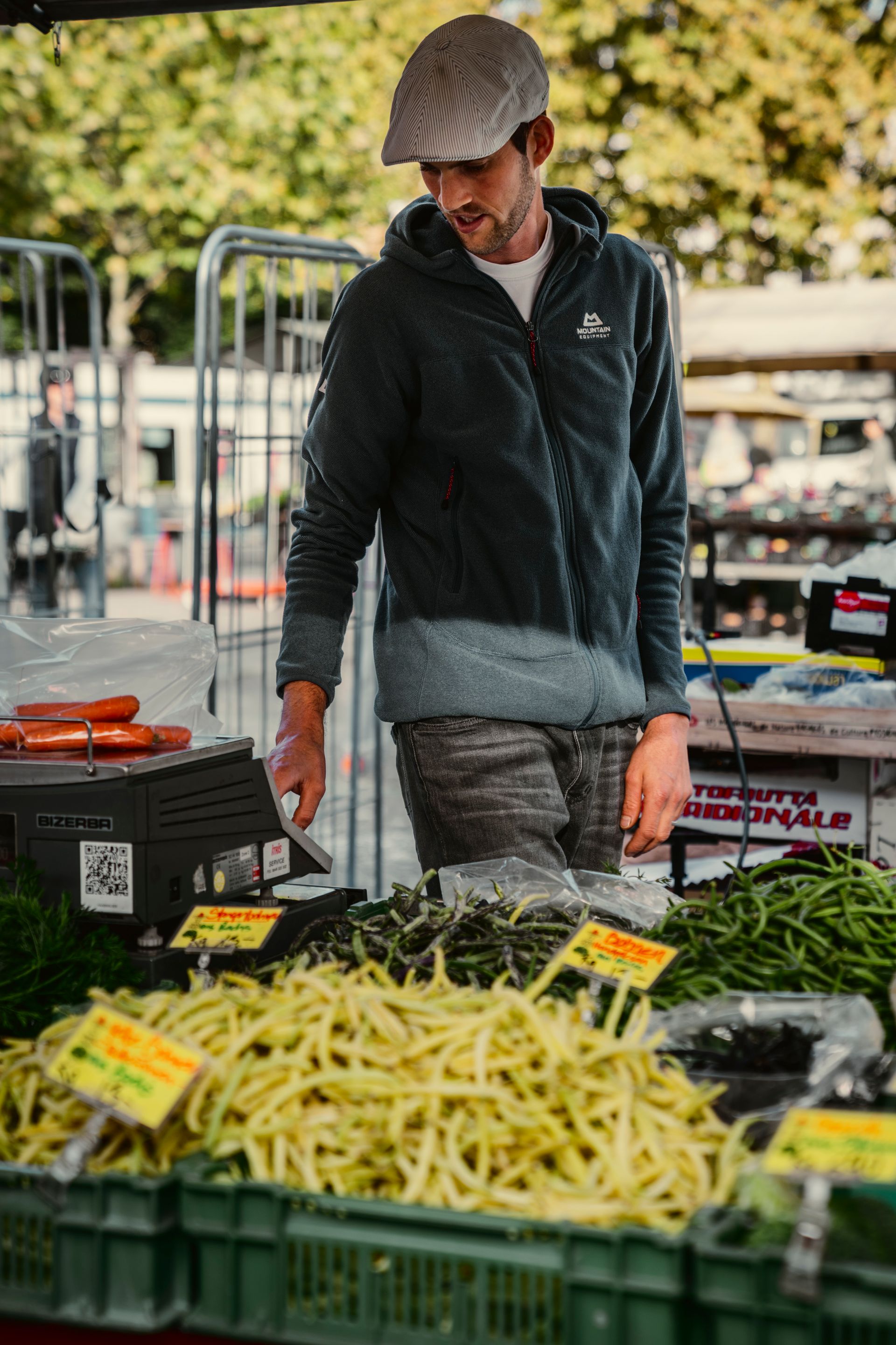 Kirschrispentomaten auf Südafrikanischem Marktstand, Männerhand hält eine Rispe in der Hand