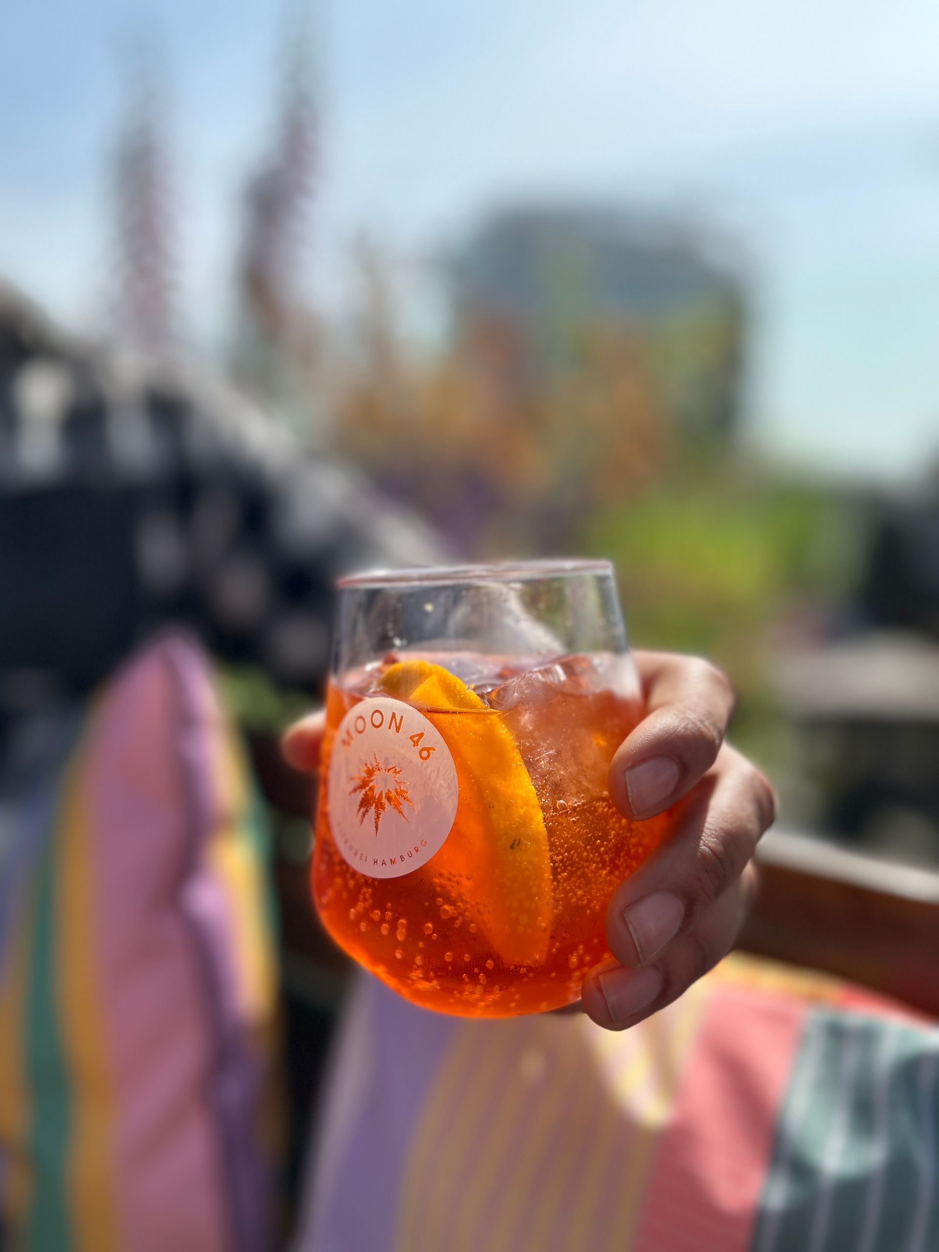 Mann mit Moon46 Glas mit Aperol Spritz in der Hand