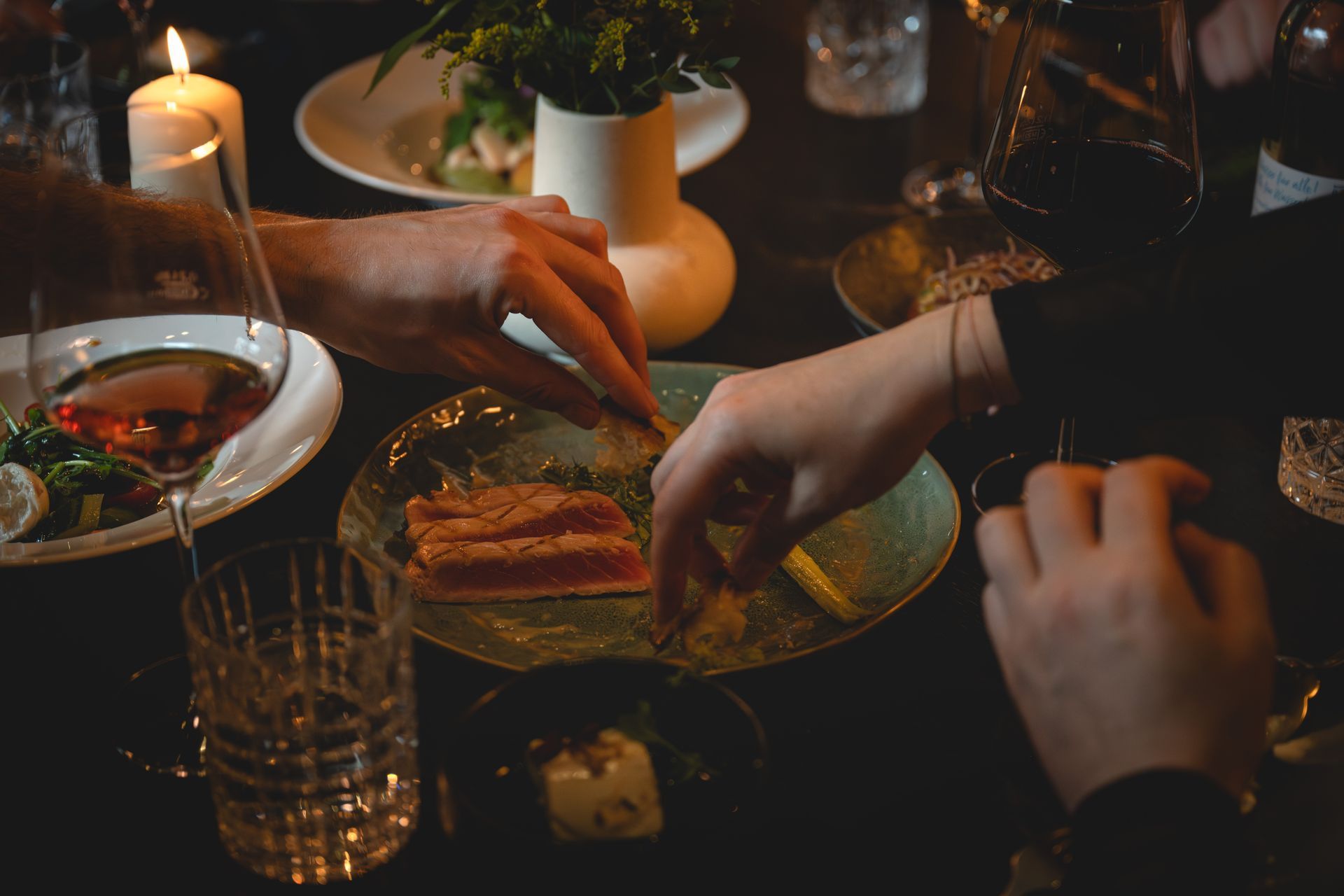 Nahaufnahme von einem edeckten Tisch im Family Style bei Kerzenschein