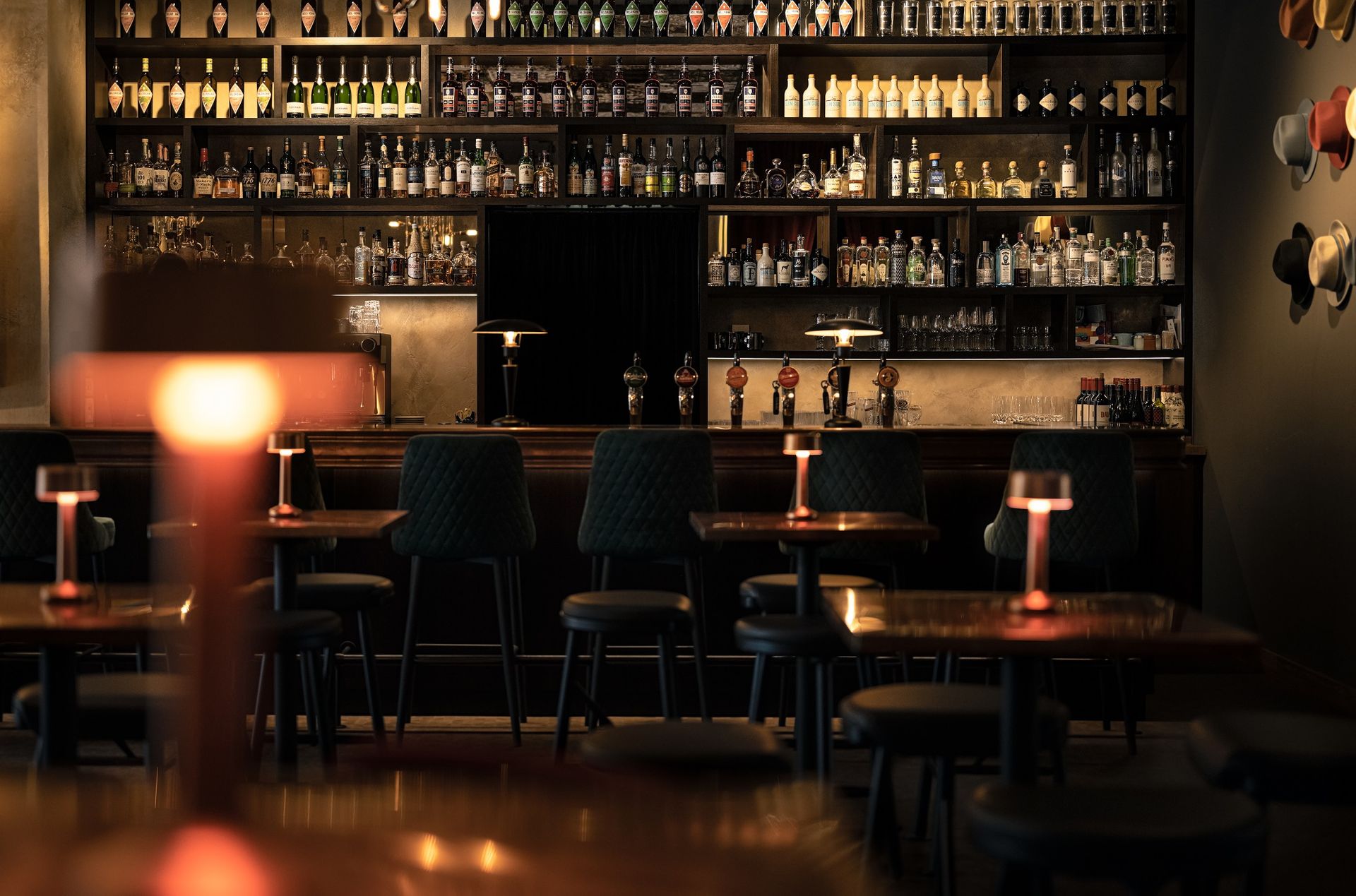 Stimmungsvolle Bar mit Flaschenregal und Kupferlampe