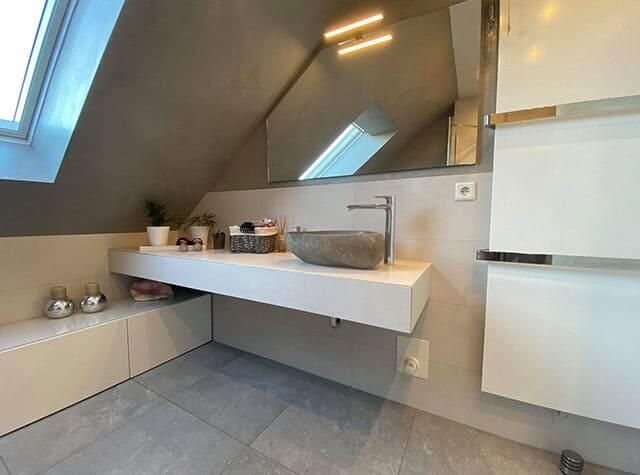 Ein Badezimmer mit Waschbecken und Spiegel an der Wand.