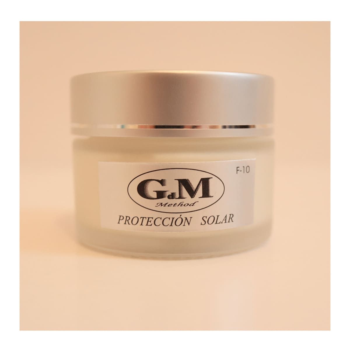 Tarro de protector solar con tapa plateada y etiqueta 