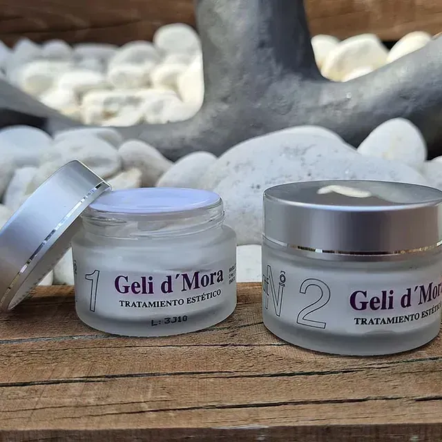 Sobre una mesa de madera hay dos tarros de geli d'mora.