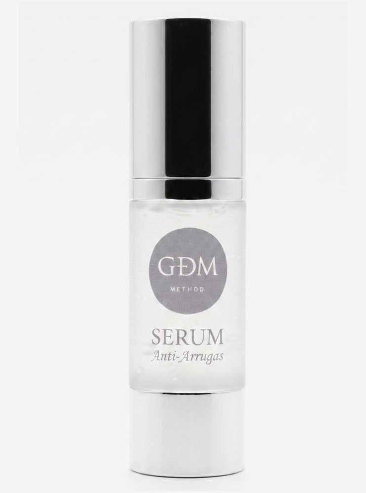 Frasco de sérum facial blanco con tapón negro y etiqueta plateada con la inscripción “GDM”.