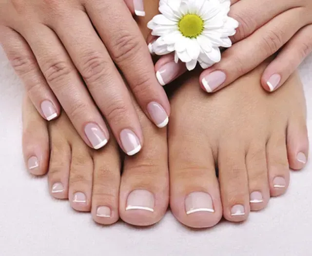 Las manos y los pies de una mujer con una flor entre ellos.