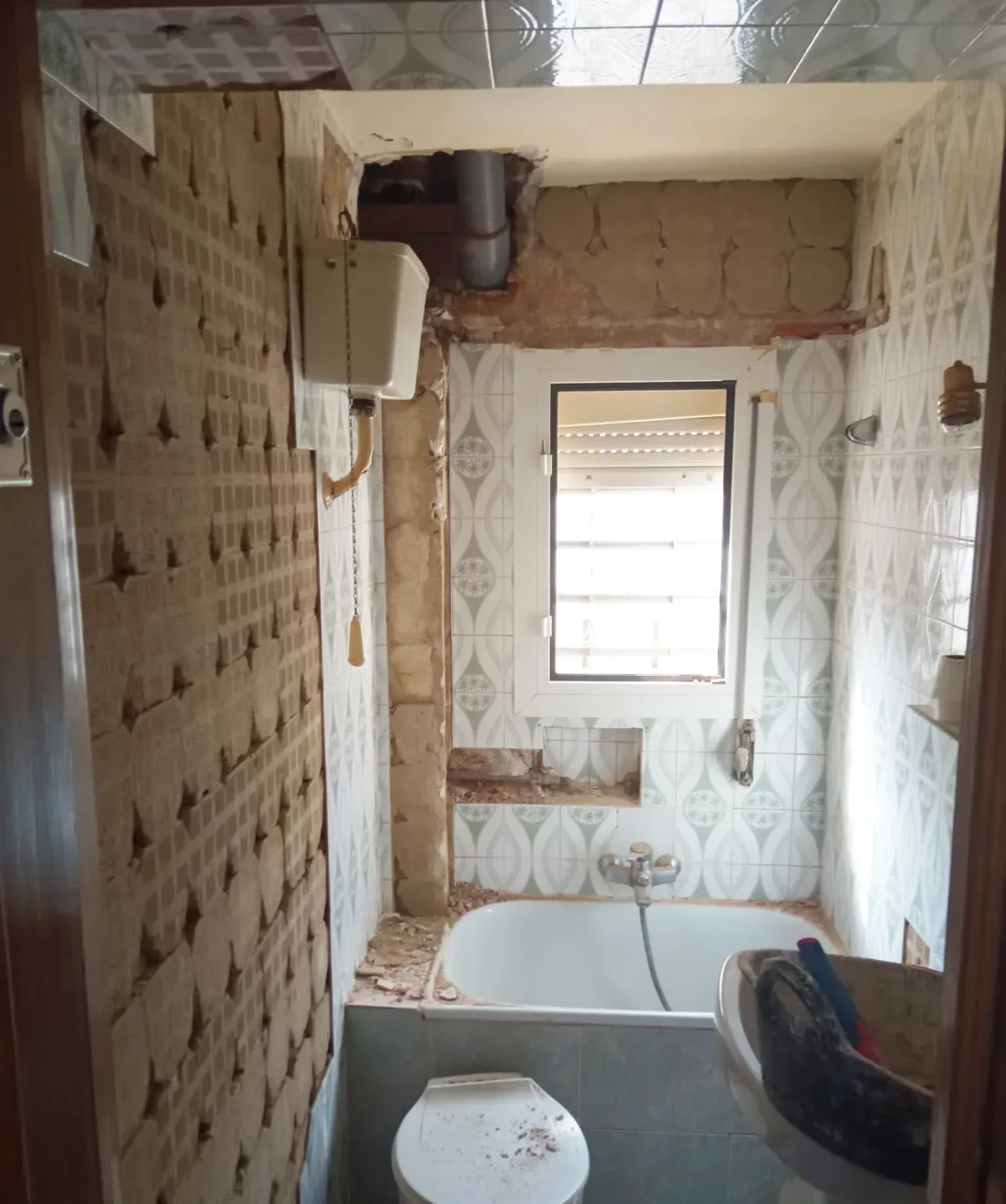 Un baño con inodoro, bañera y ventana.
