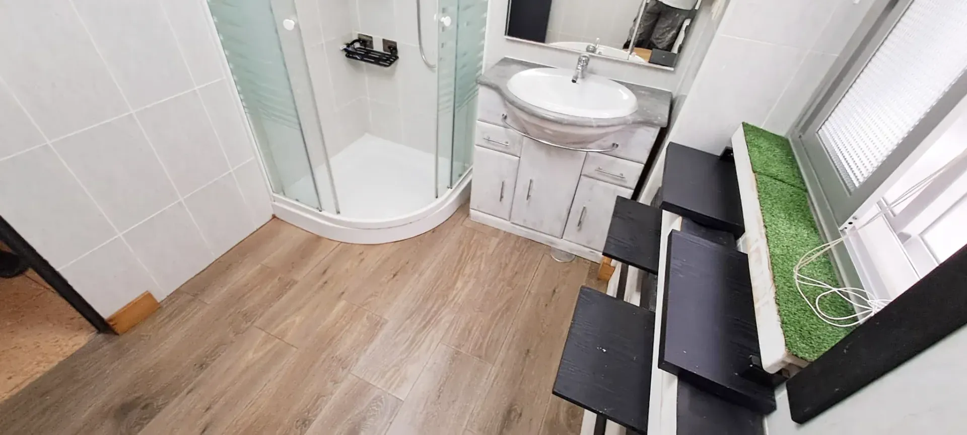 Un baño con lavabo, ducha y escaleras.