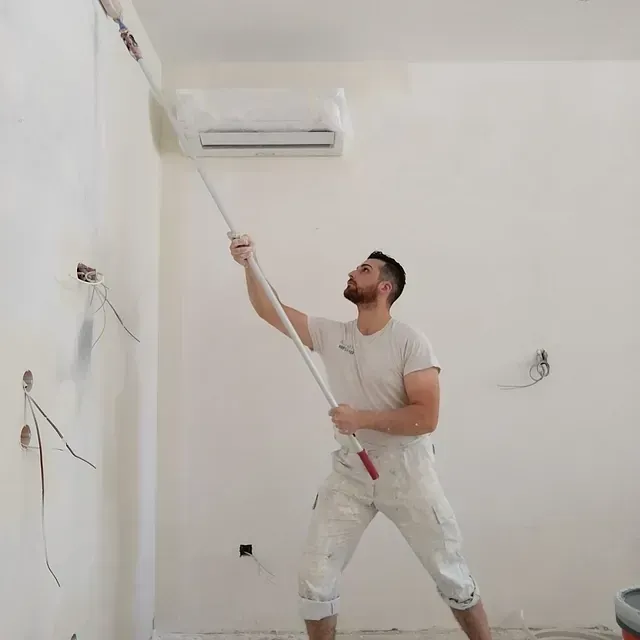 Un hombre está pintando una pared con un rodillo.