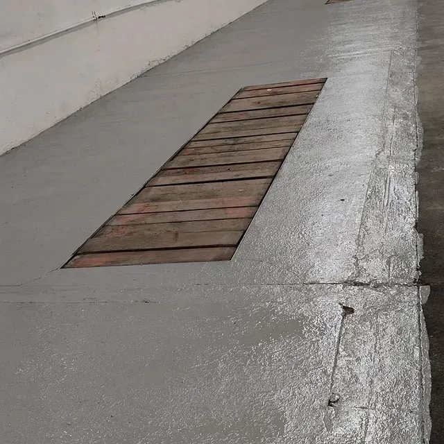 Una acera de hormigón con una tabla de madera en el medio