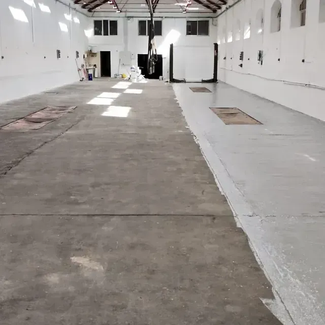 Un almacén vacío con suelo de hormigón y paredes blancas.