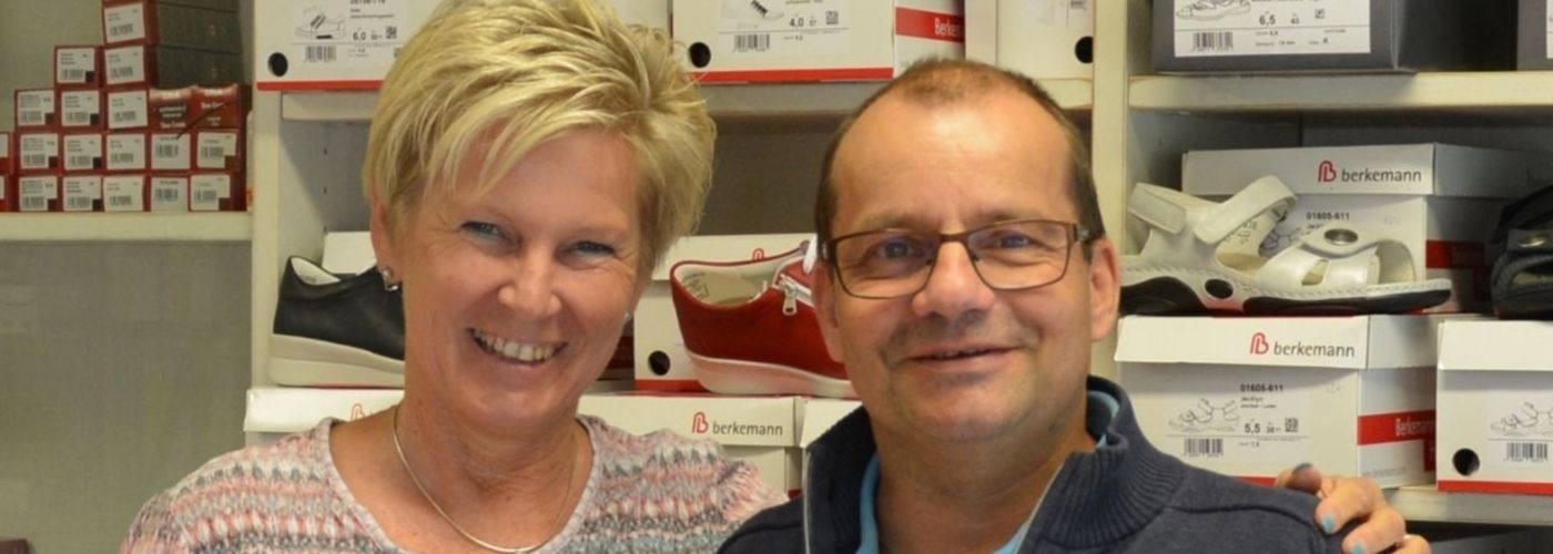 Ein Mann und eine Frau posieren in einem Schuhgeschäft für ein Foto.