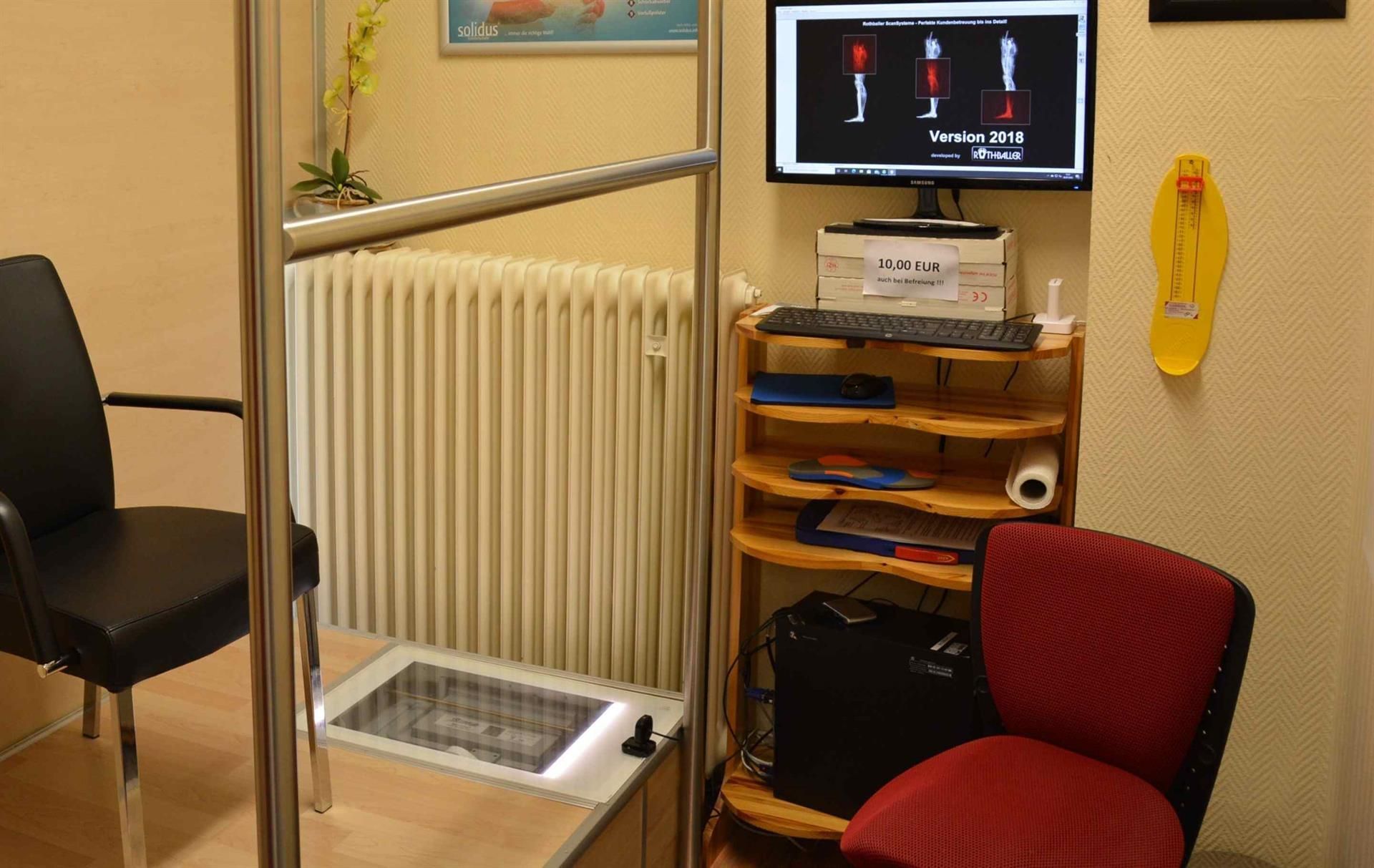 Ein Wartezimmer mit einem Stuhl und einem Computermonitor