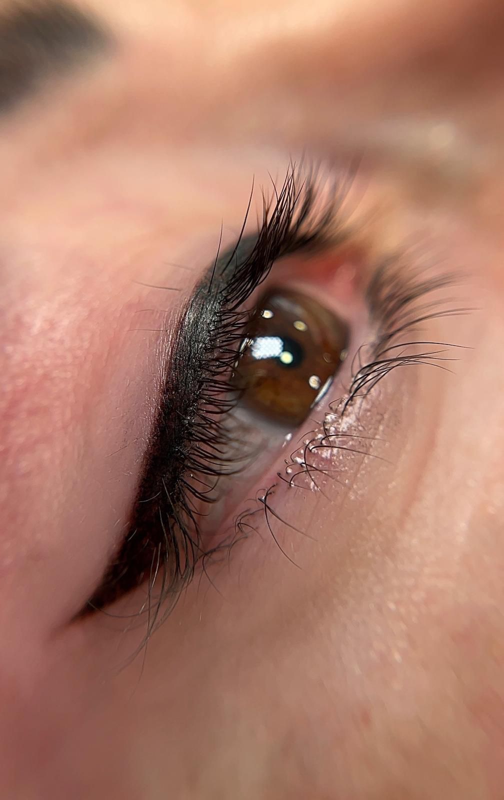 Primer plano y vista en ángulo de un ojo con delineador de ojos permanente oscuro