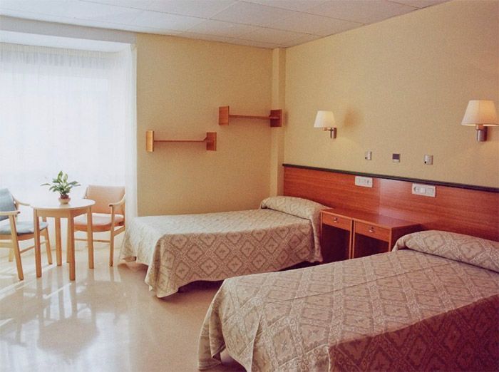 Una habitación de hotel con dos camas y una mesa