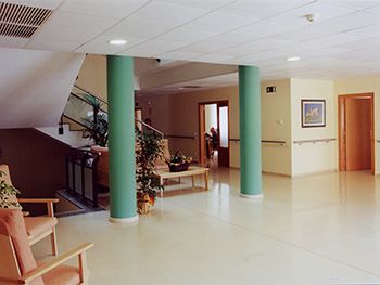 Una habitación grande con una escalera y sillas.