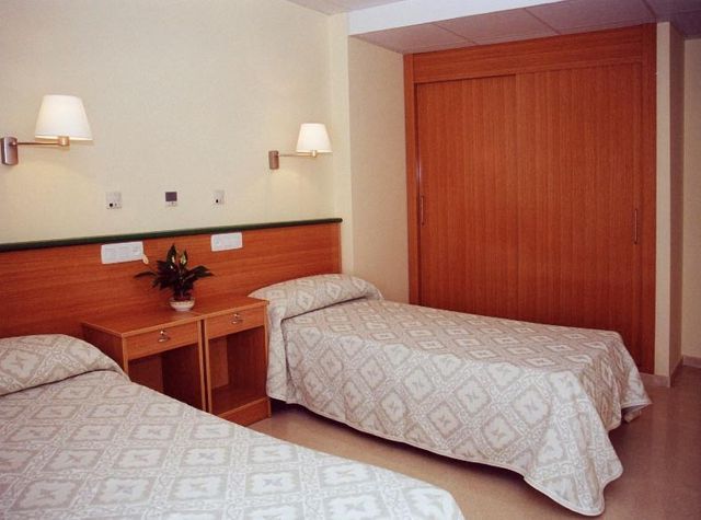 Una habitación de hotel con dos camas y un armario.