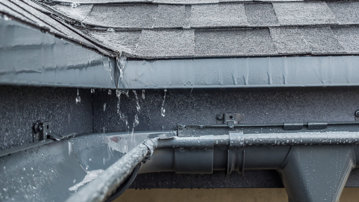 Pluie coulant sur une toiture dans une gouttière