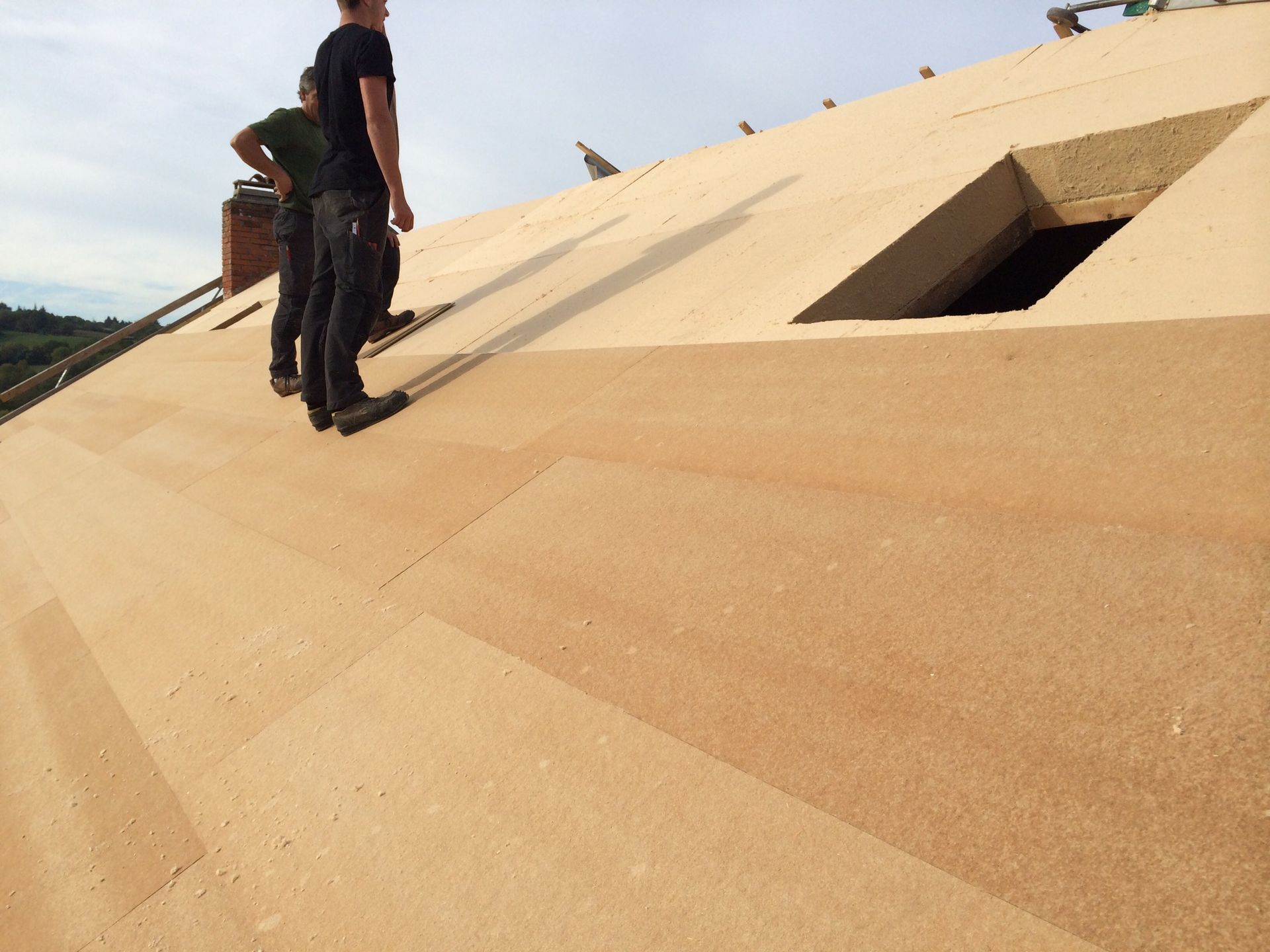 Professionnels sur une toiture en cours de pose d'isolation
