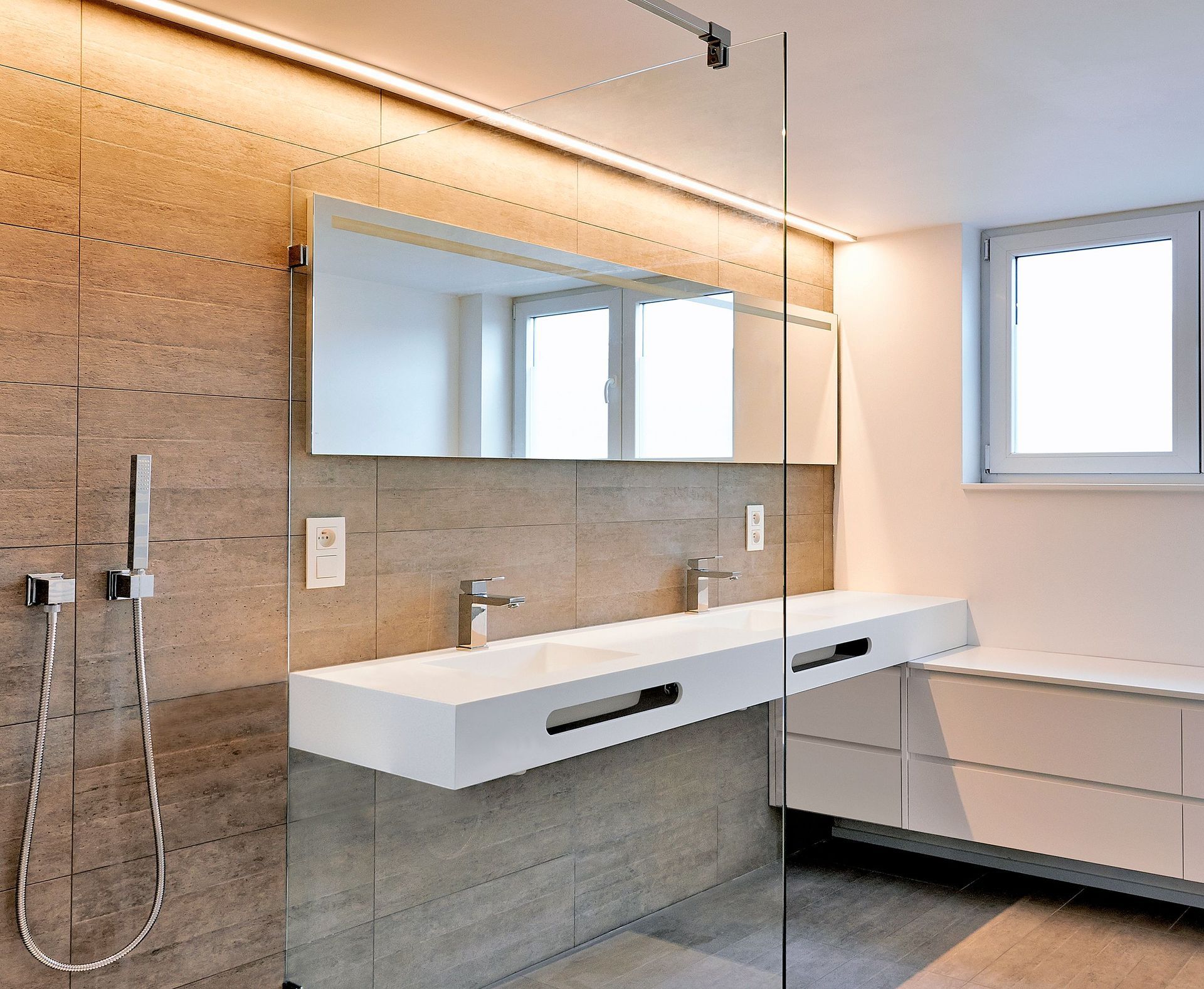 Un baño con dos lavabos y ducha a ras de suelo.