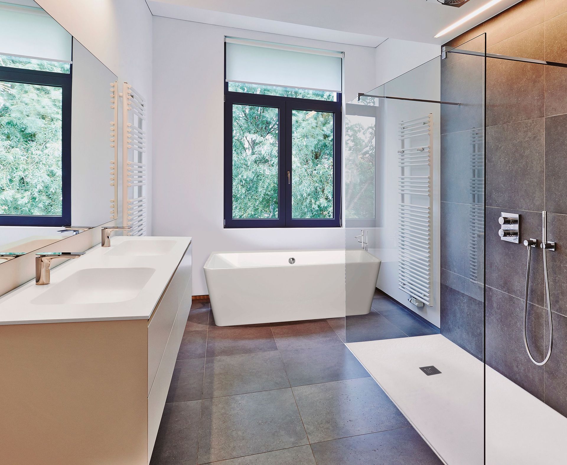 Un baño con dos lavabos, una bañera y una ducha a ras de suelo.