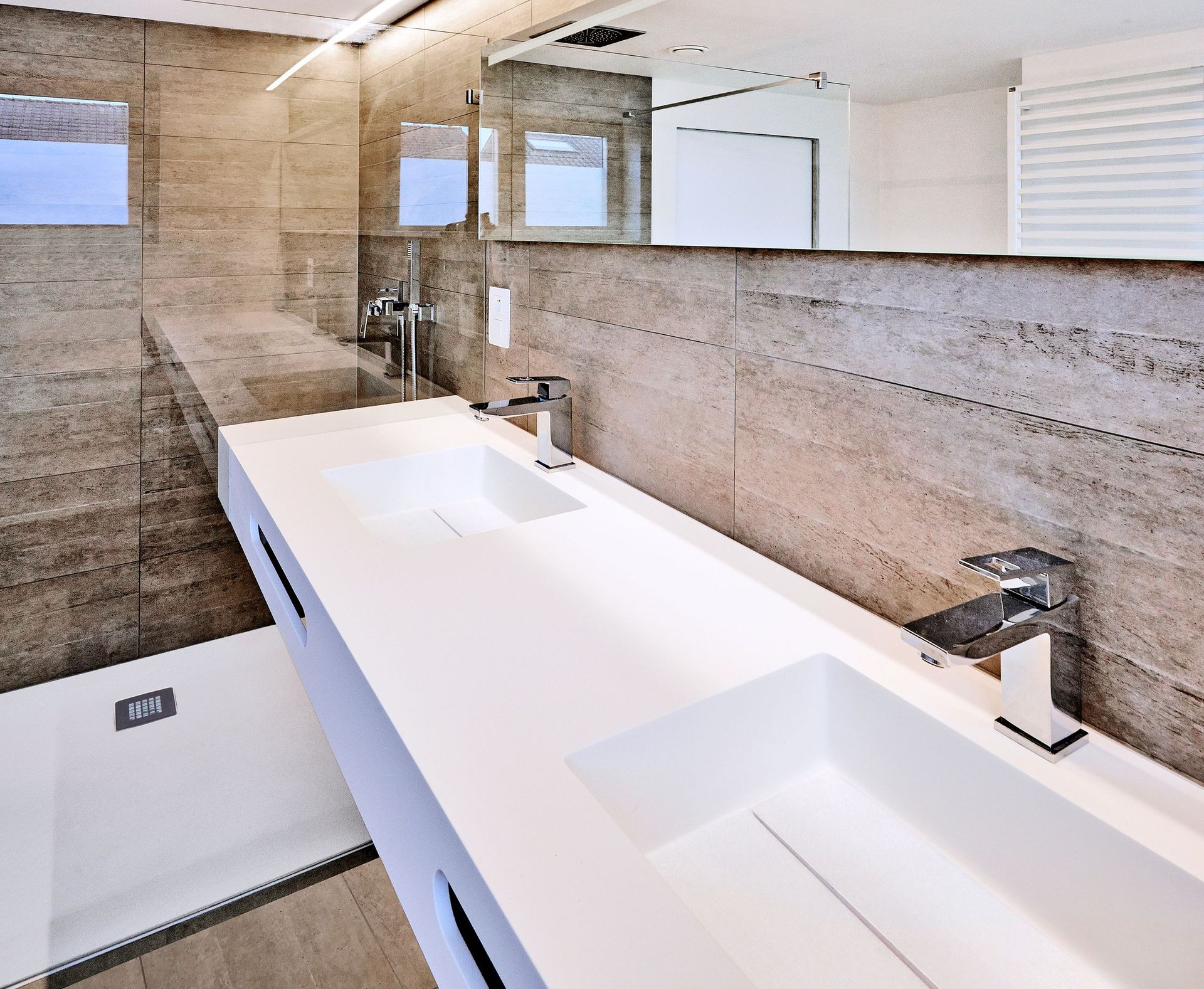 Un baño con dos lavabos y un espejo grande.