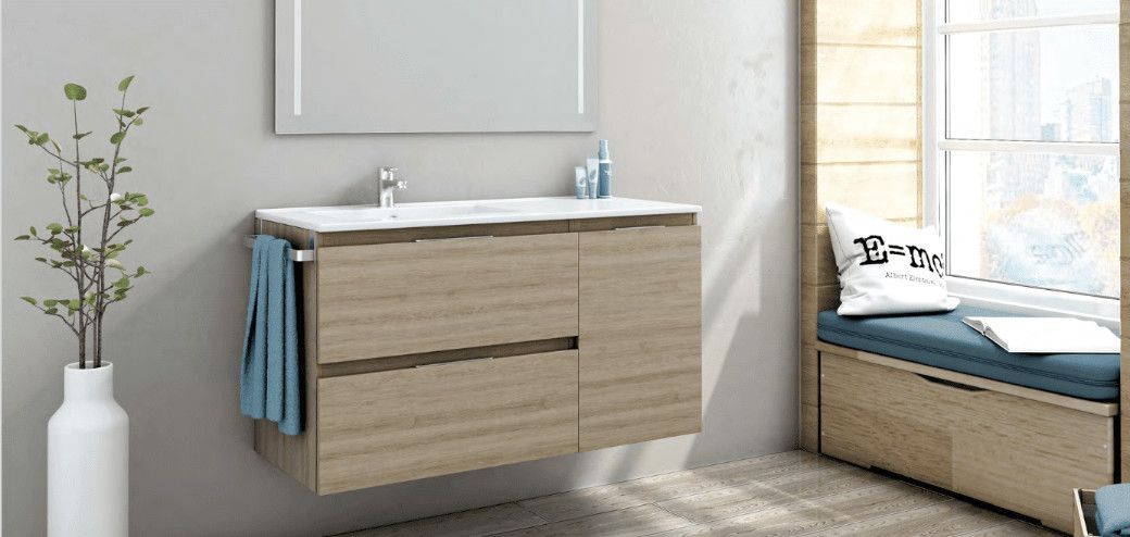 Un baño con lavabo, espejo y asiento junto a la ventana.