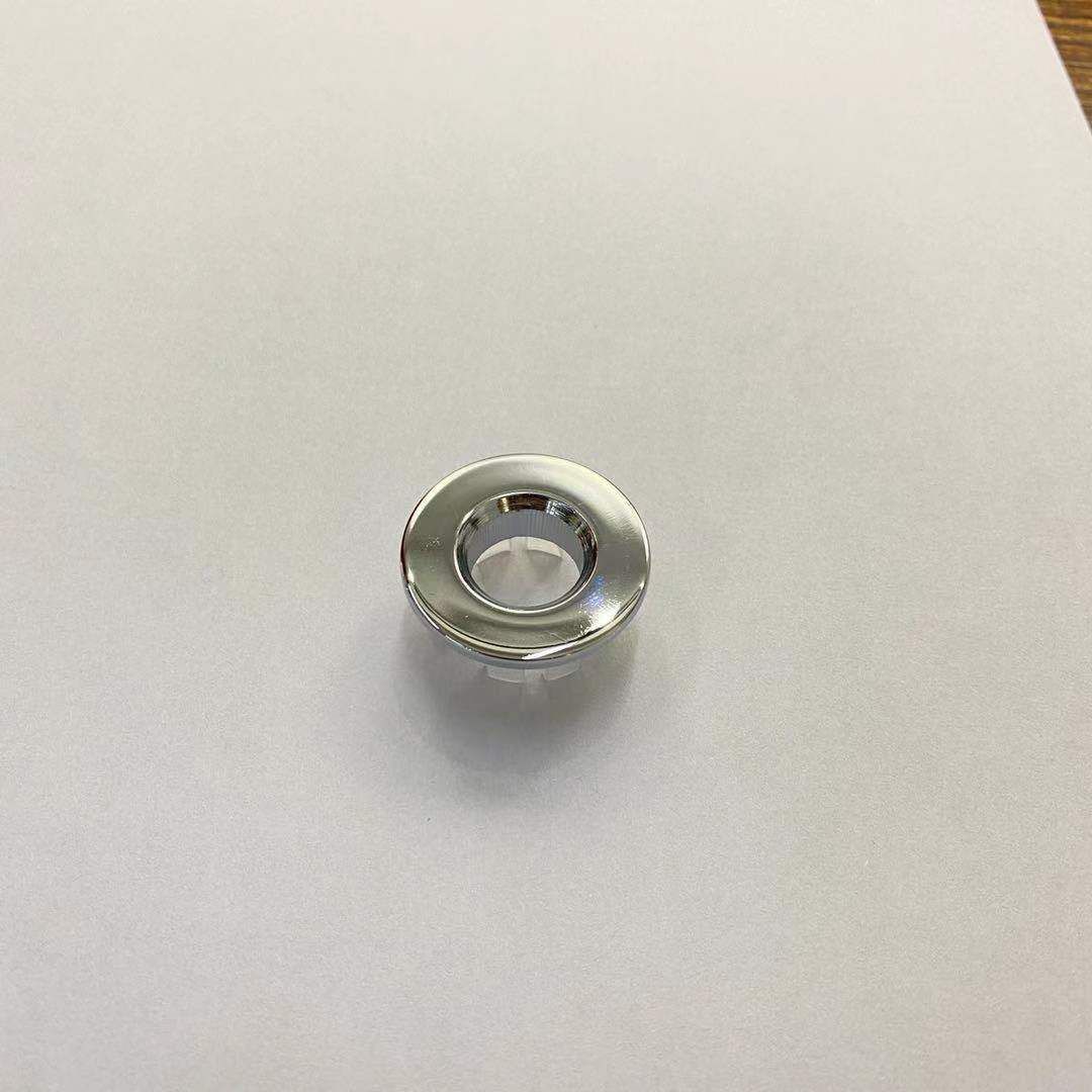 Un pequeño anillo de metal con un agujero en el medio está sobre un trozo de papel.