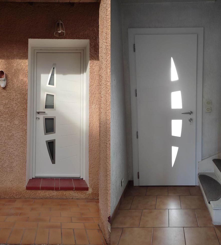 Deux portes blanches avec des panneaux de verre abstraits dans l'entrée d'un bâtiment.
