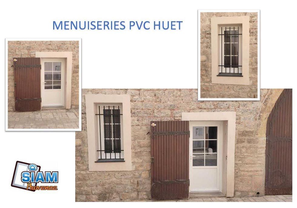 Fenêtres et portes PVC HUET exposées sur un bâtiment en pierre.