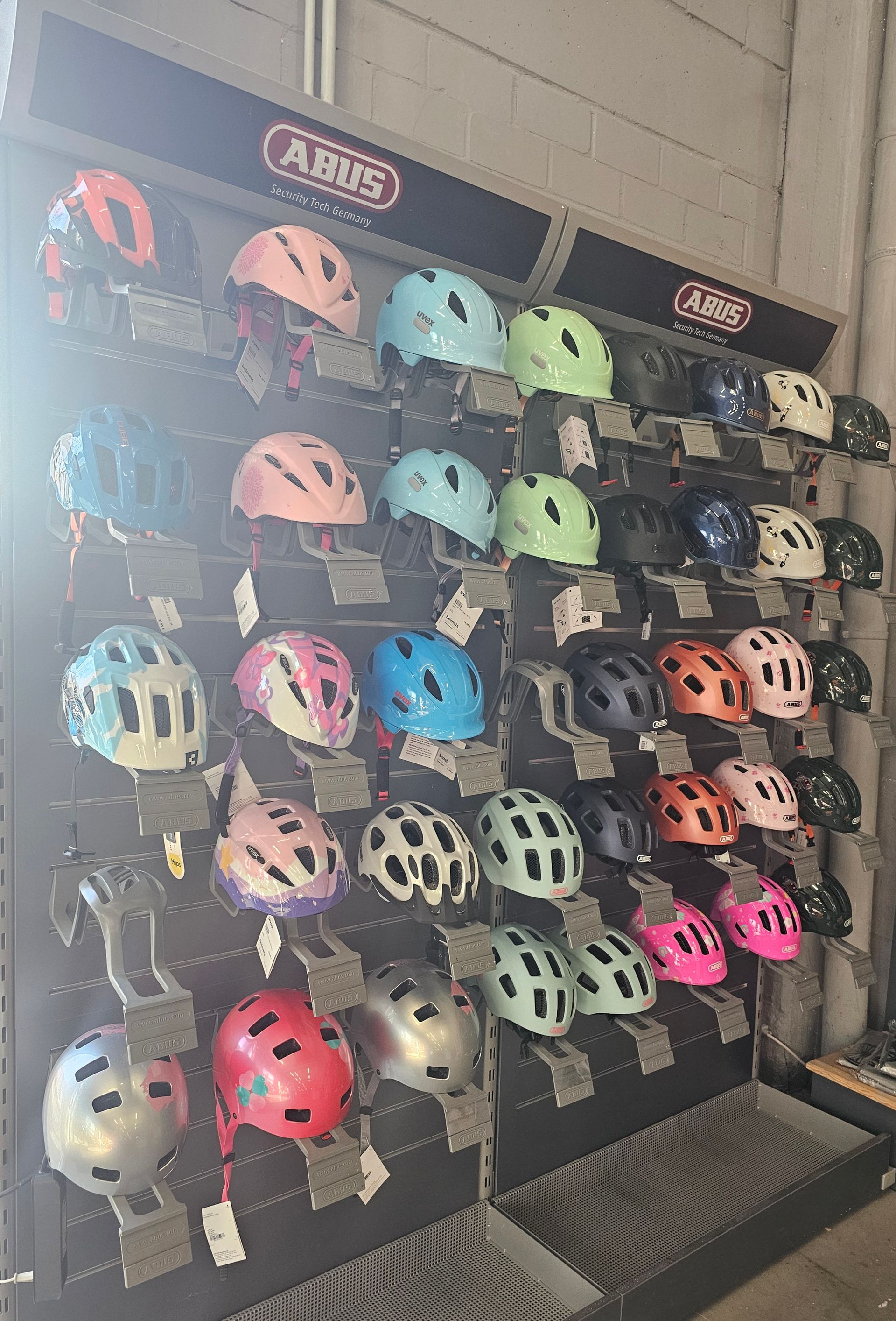 Fahrradhelme in verschiedenen Farben und Größen an der Wand