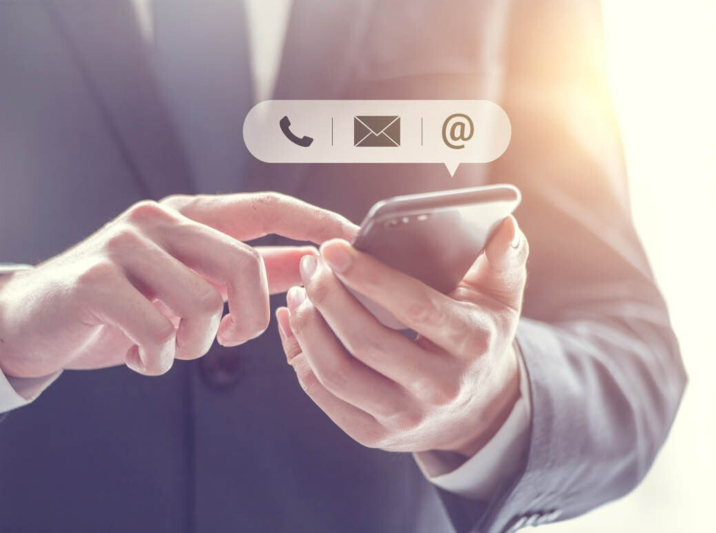 Montage avec des pictogrammes d'un téléphone, courriel et e-mail sur un smartphone utilisé par un homme