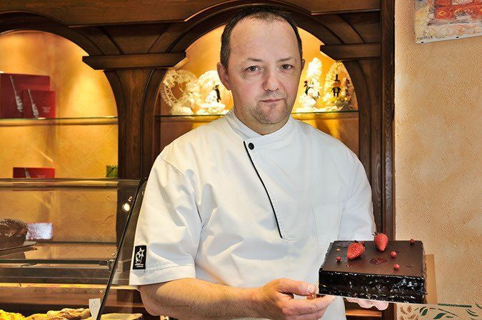 Pâtissier avec un gâteau au chocolat