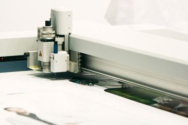 Una máquina está cortando un trozo de papel sobre una mesa.