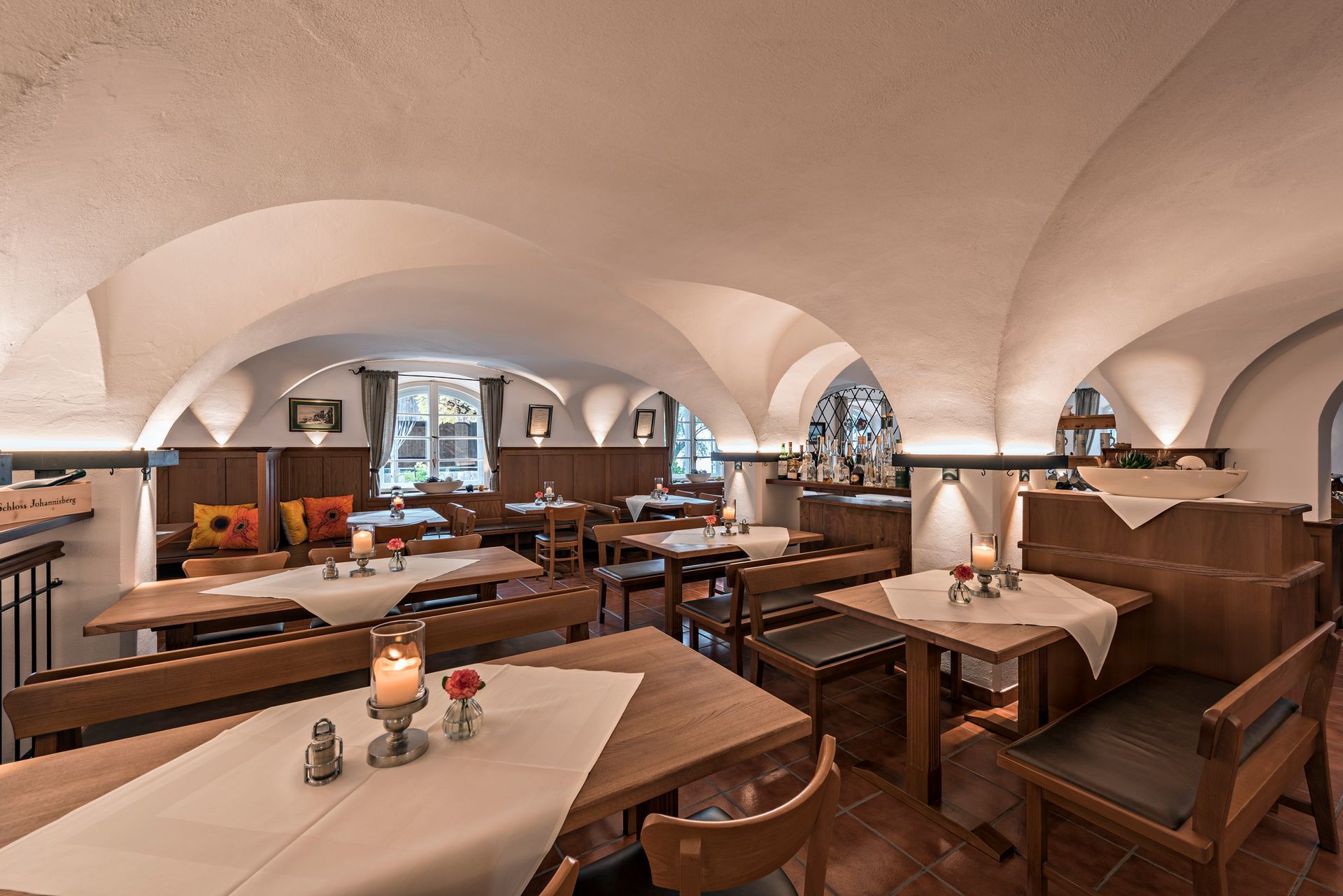 Räumlichkeit innen, hölzerne Tische und Stühle mir ordentlich gedeckten Tischen, gemütliche Atmosphäre