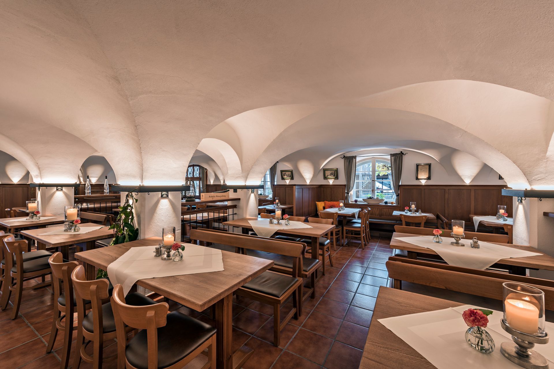 Räumlichkeit innen, hölzerne Tische und Stühle mir ordentlich gedeckten Tischen, gemütliche Atmosphäre