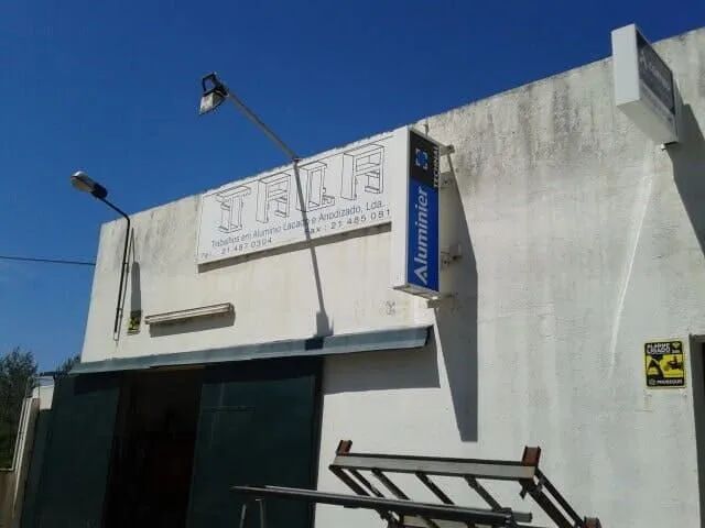 Um prédio branco com uma placa que diz talia