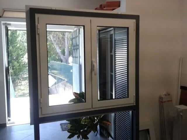Uma janela em uma sala com uma planta na frente dela