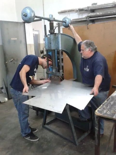 Dois homens estão trabalhando em uma máquina em uma fábrica