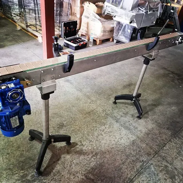 Una cinta transportadora con un motor azul conectado a ella.