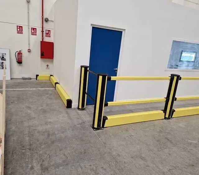 Un almacén con una valla amarilla y una puerta azul.