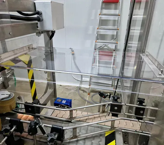 Una cinta transportadora en una fábrica con una escalera al fondo