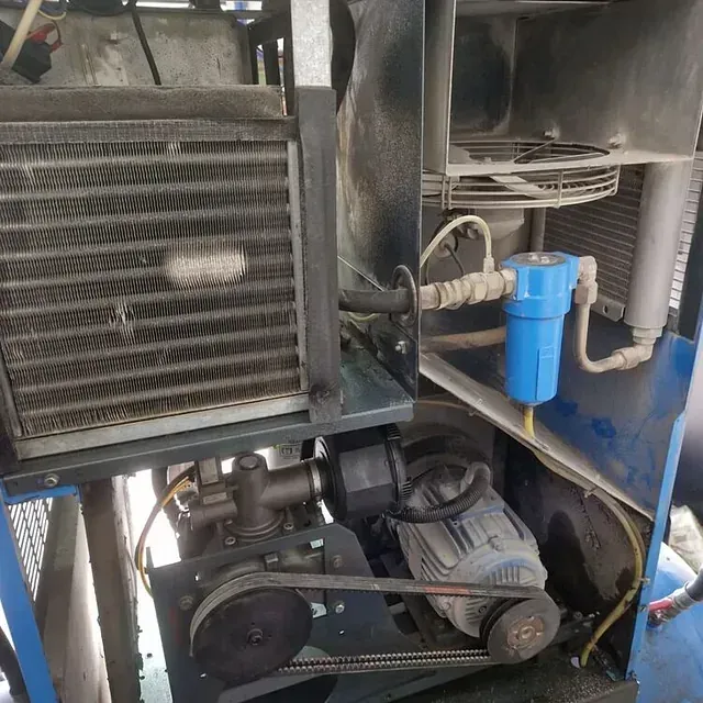 El interior de un compresor de aire con un filtro azul conectado.