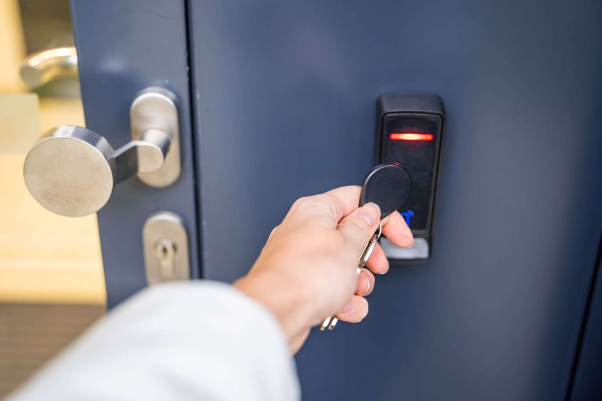 Une main présentant un badge d'ouverture de porte